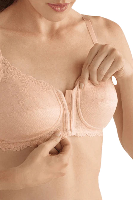 Woman wearing a beige bra with lace details on a white background