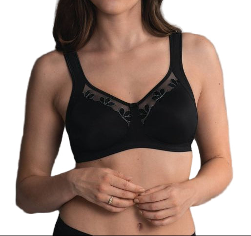 Woman wearing a black bra against a gray background