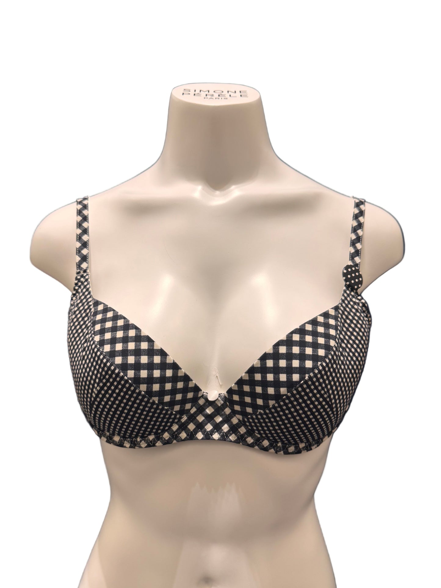 Black and white checkered bra on a mannequin against a dark background