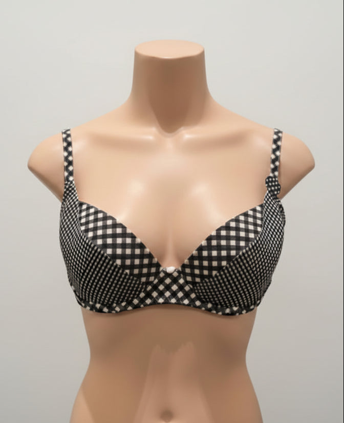 Black and white checkered bra on a mannequin against a dark background