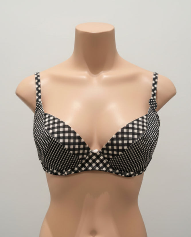 Black and white checkered bra on a mannequin against a dark background