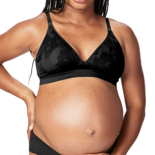 Pregnant woman wearing a black maternity bra and underwear set on a white background