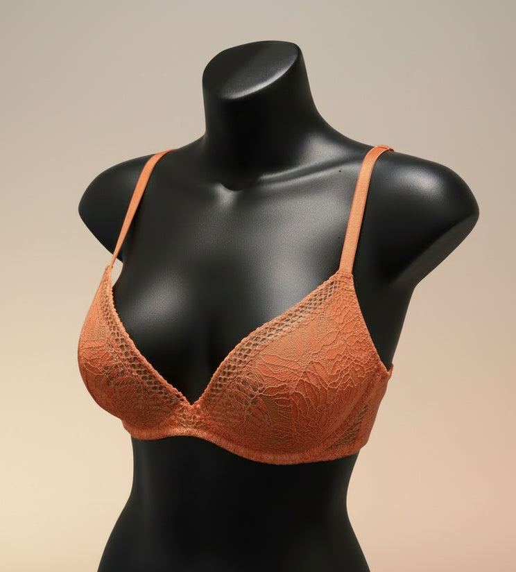 Orange bra on a mannequin against a blue textured background