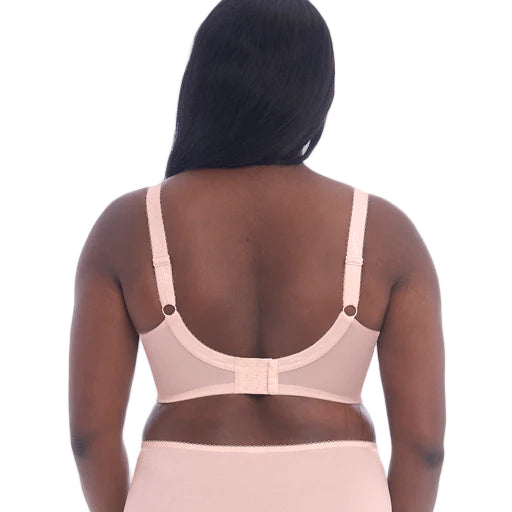 Woman wearing a beige bra and underwear set on a white background