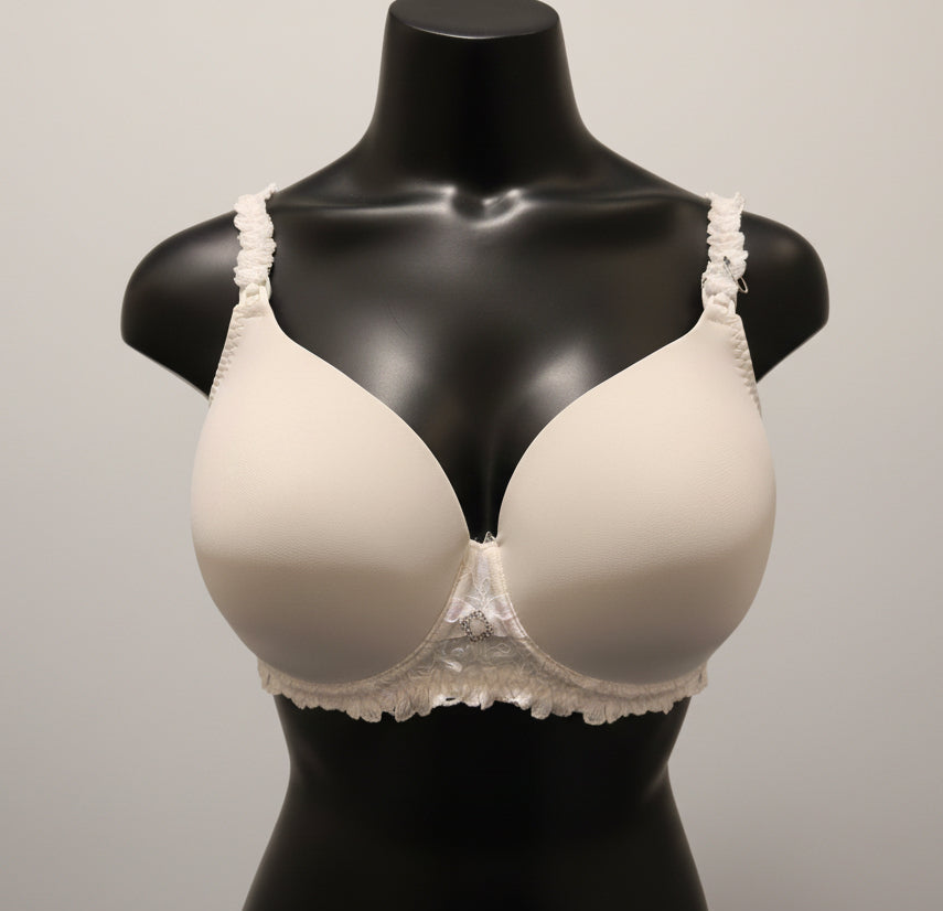 White bra with lace details on a mannequin against a dark background