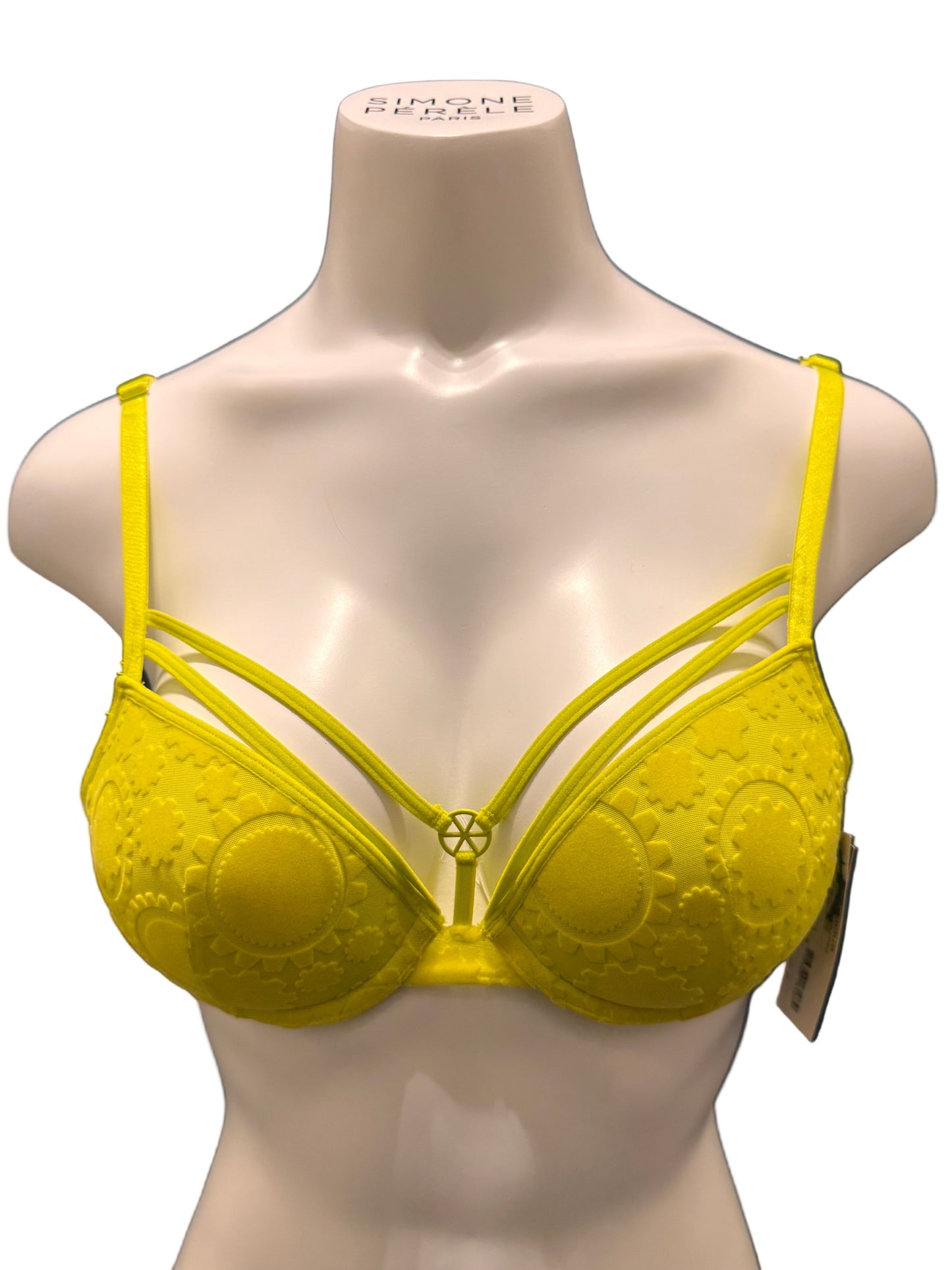 Yellow bikini top on a mannequin against a dark background