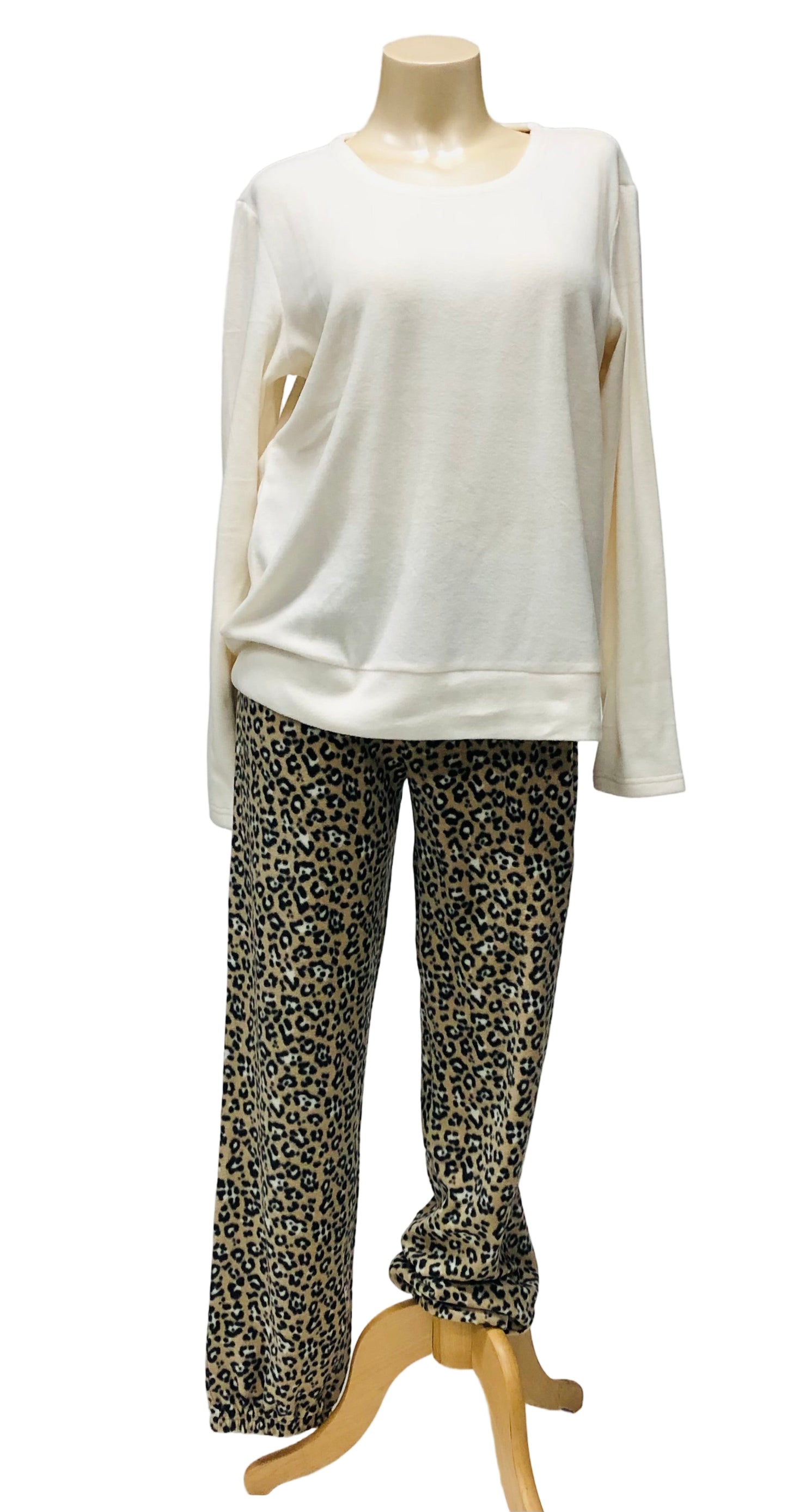 Mannequin wearing a white top and leopard print pants on a plain background