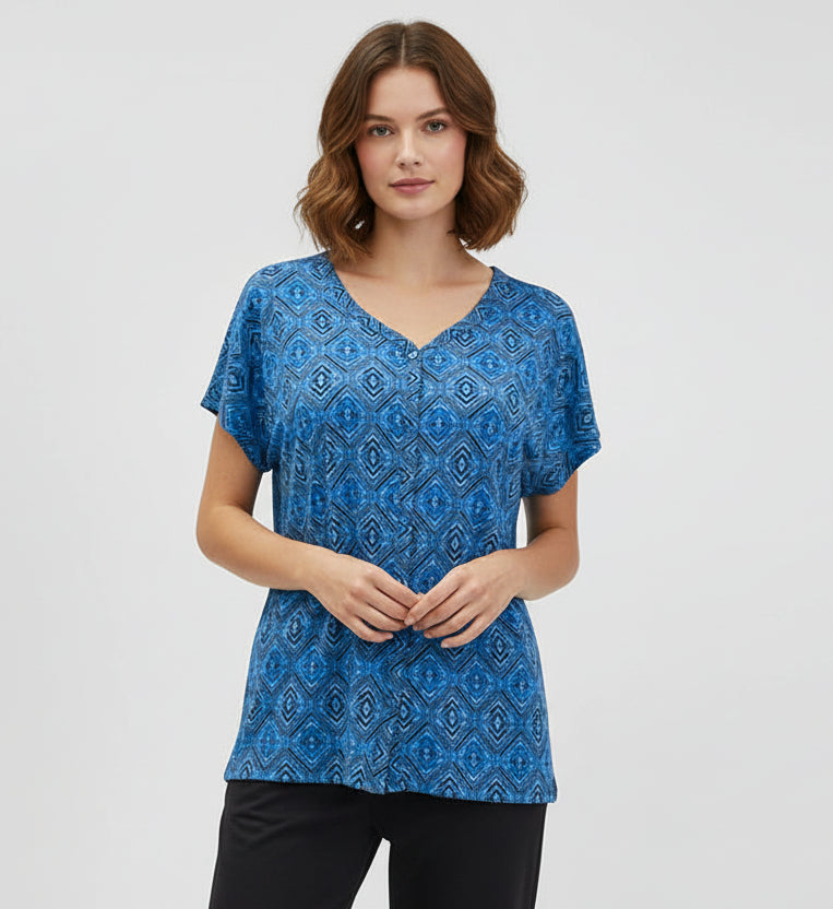 Blue patterned top on a mannequin against a gray background