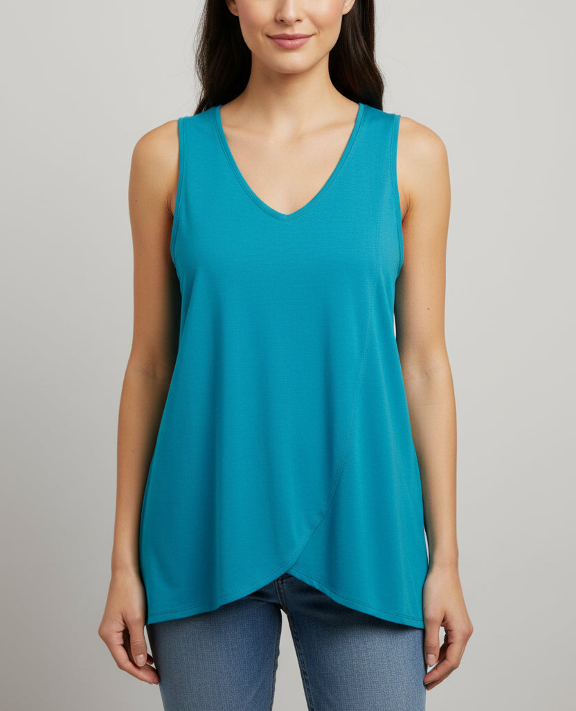 Woman wearing a teal sleeveless top against a gray background