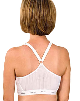 Person wearing a white bralette with thin straps on a beige background