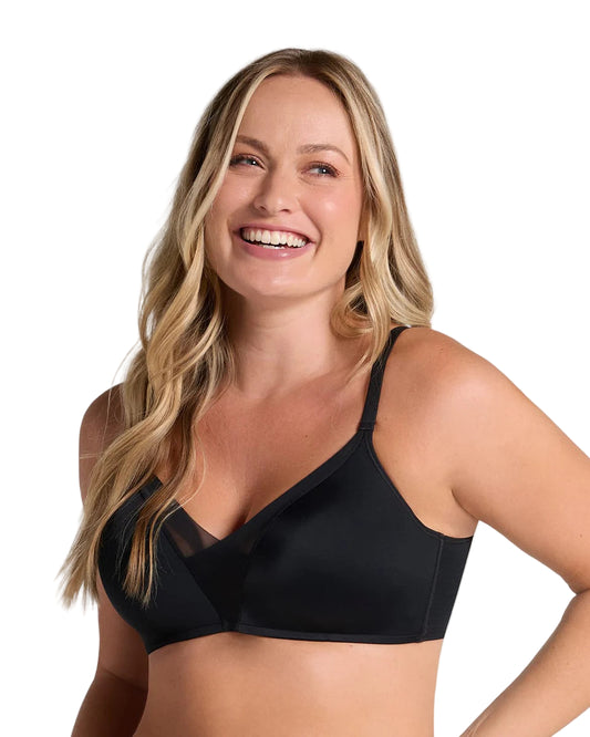 Woman wearing a black bra against a beige background
