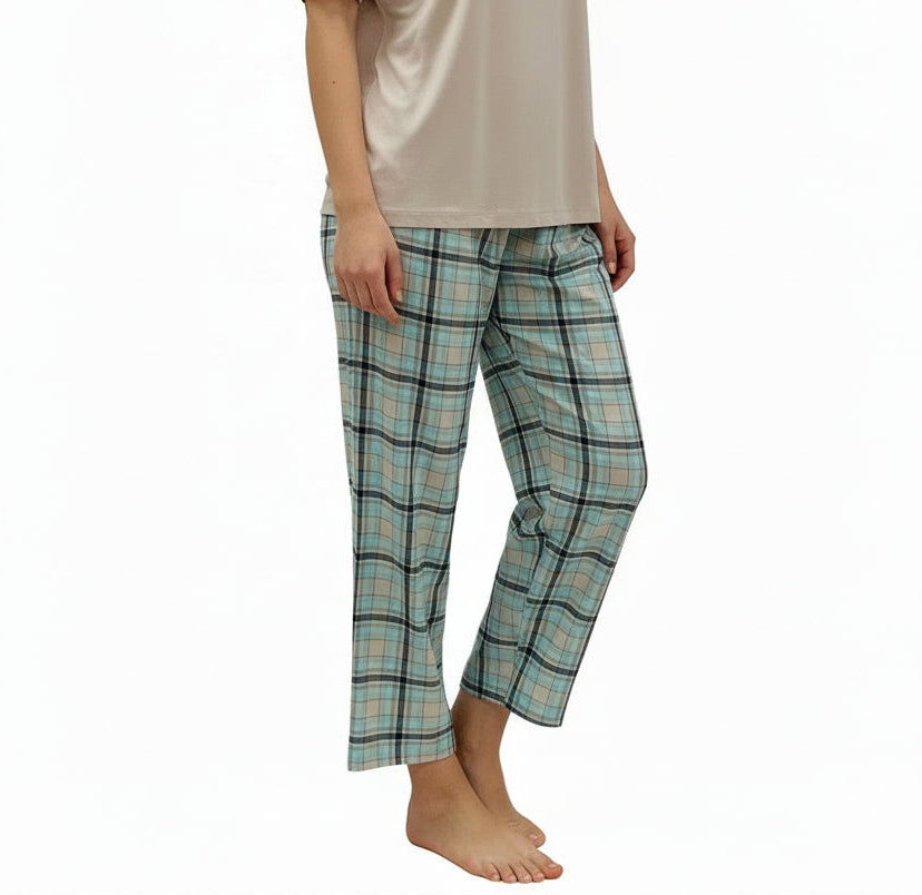 Mannequin wearing a beige top and plaid pajama pants on a white background