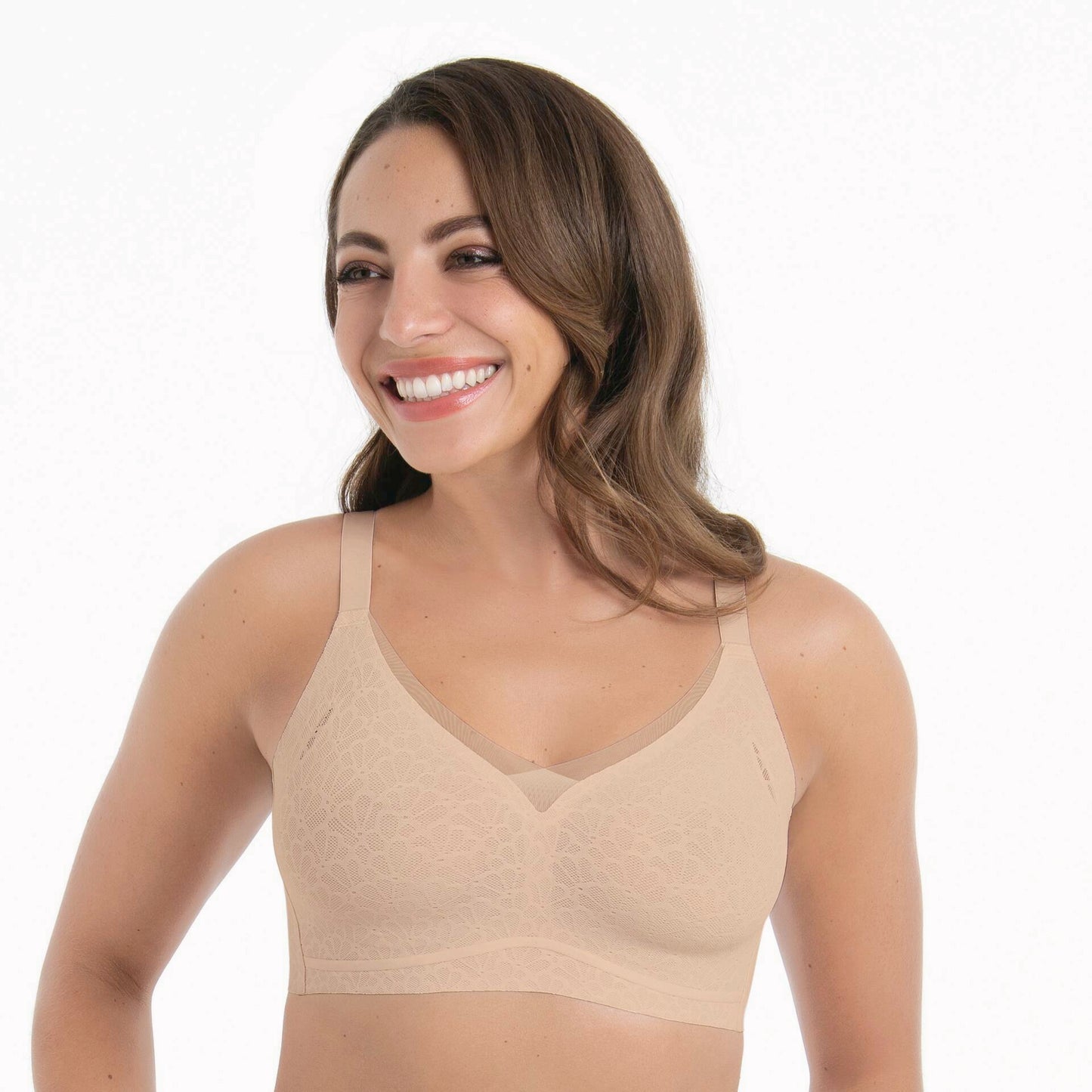 Woman wearing a beige bralette on a white background