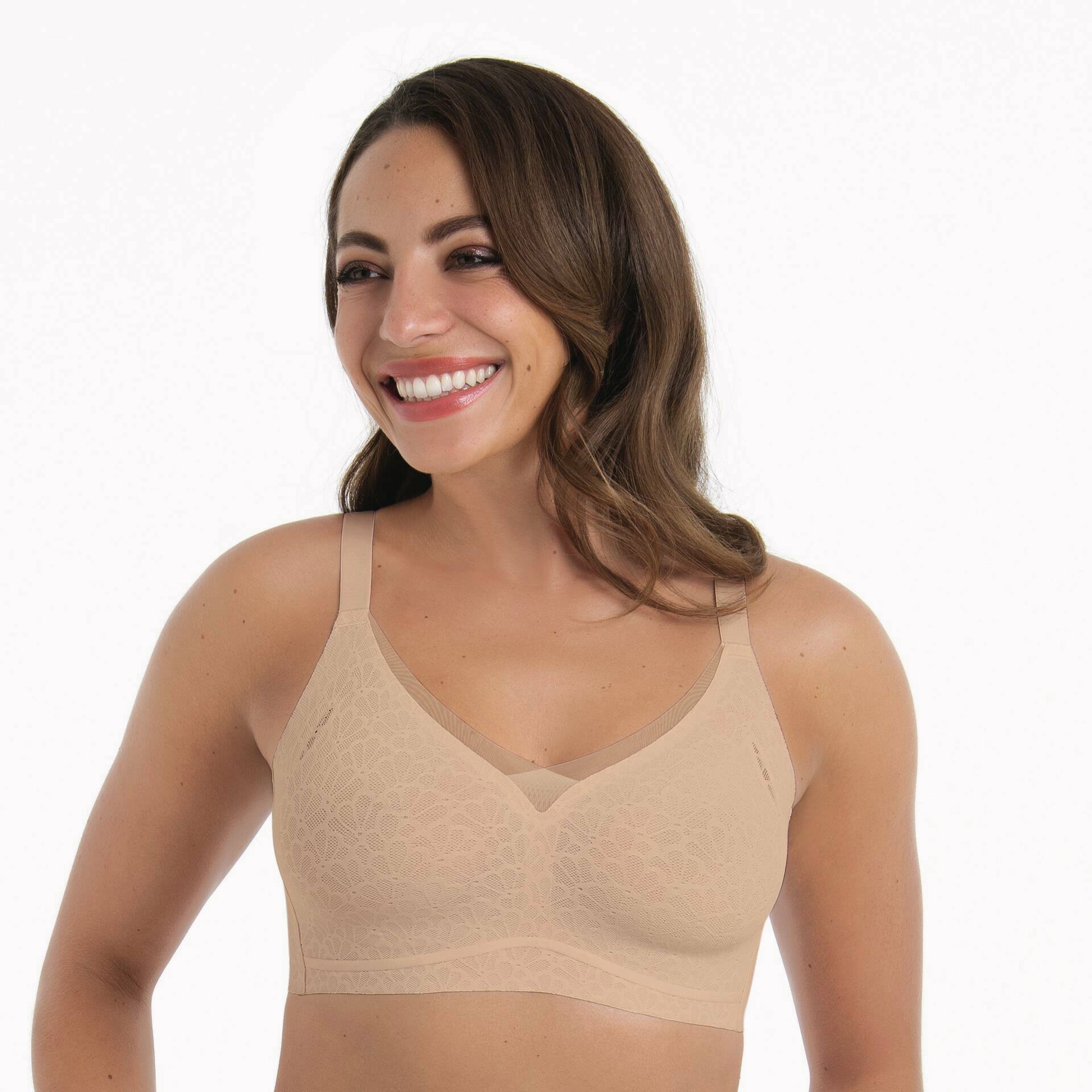 Woman wearing a beige bralette on a white background