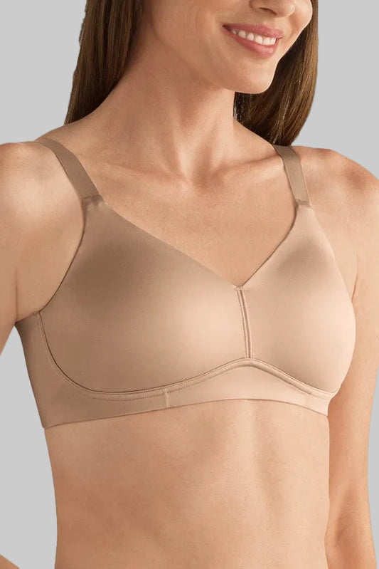 Woman wearing a beige bra against a neutral background