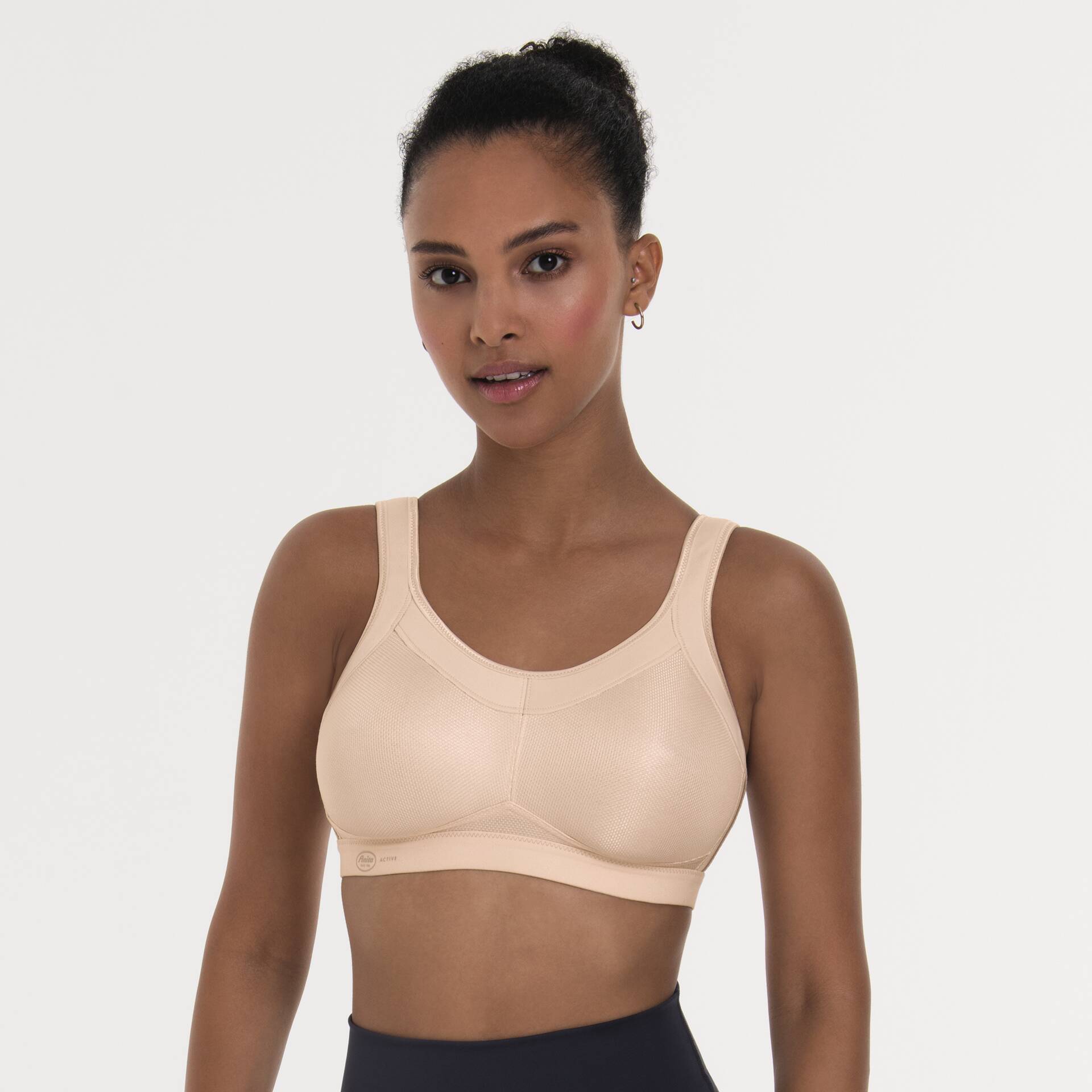 Woman wearing a beige sports bra against a plain background
