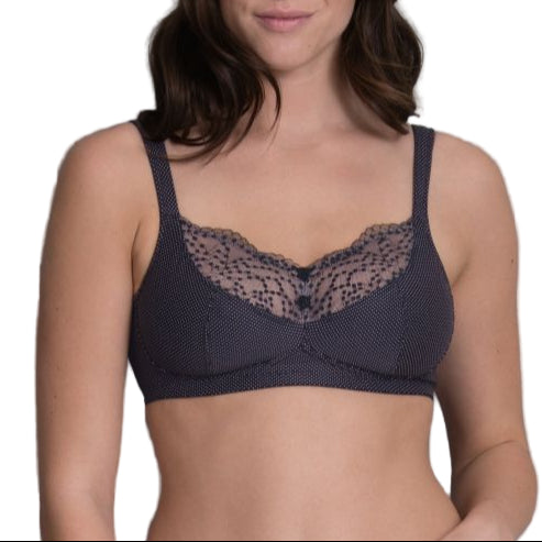 Woman wearing a navy blue bralette with lace detailing against a gray background