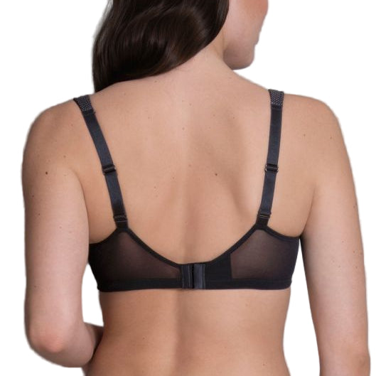 Woman wearing a black bra against a gray background