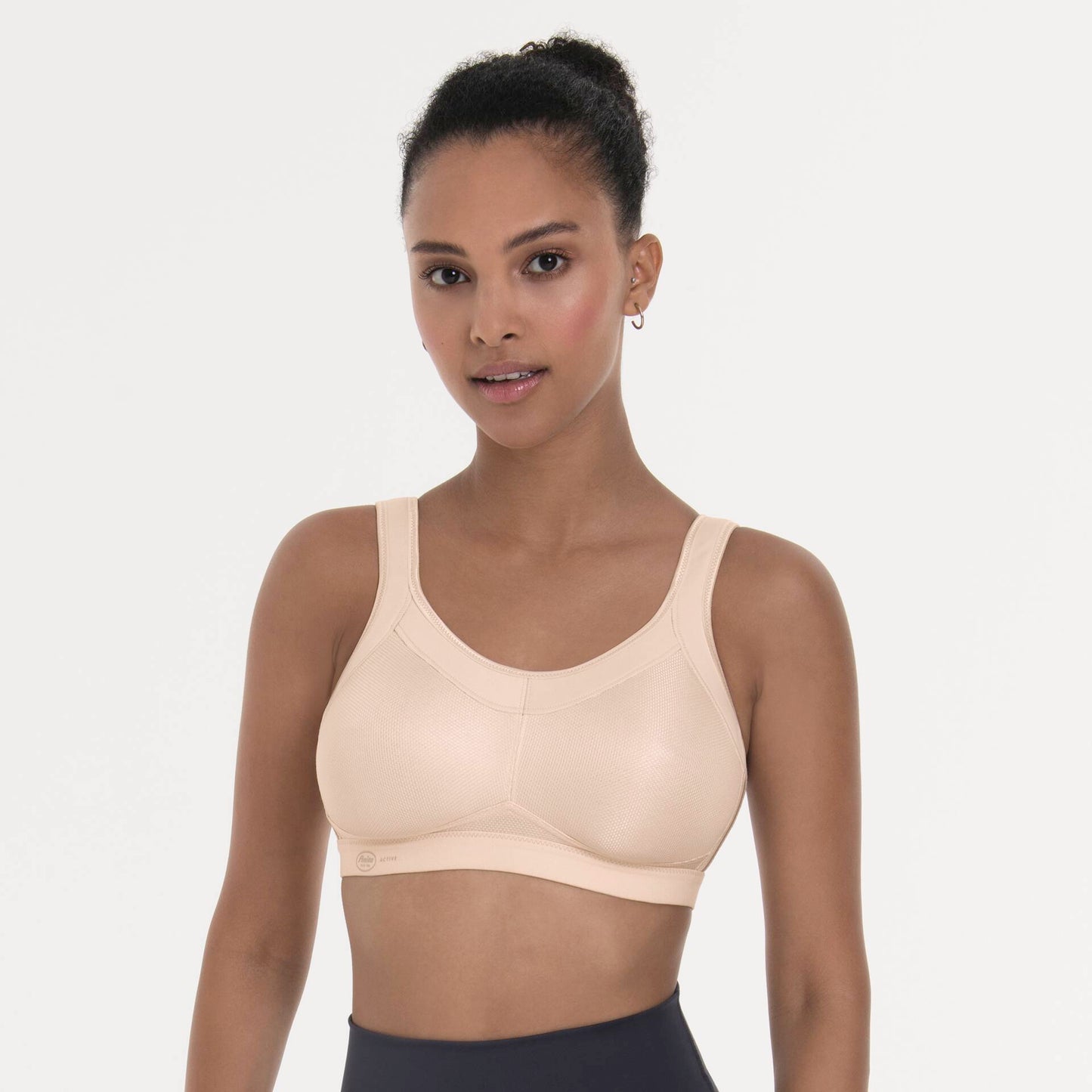 Woman wearing a beige sports bra against a plain background