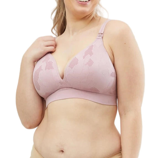 Woman wearing a pink bra and beige underwear set on a light gray background