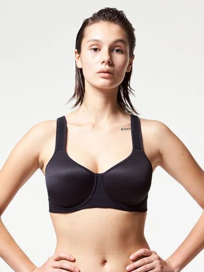Woman wearing a black sports bra against a plain background