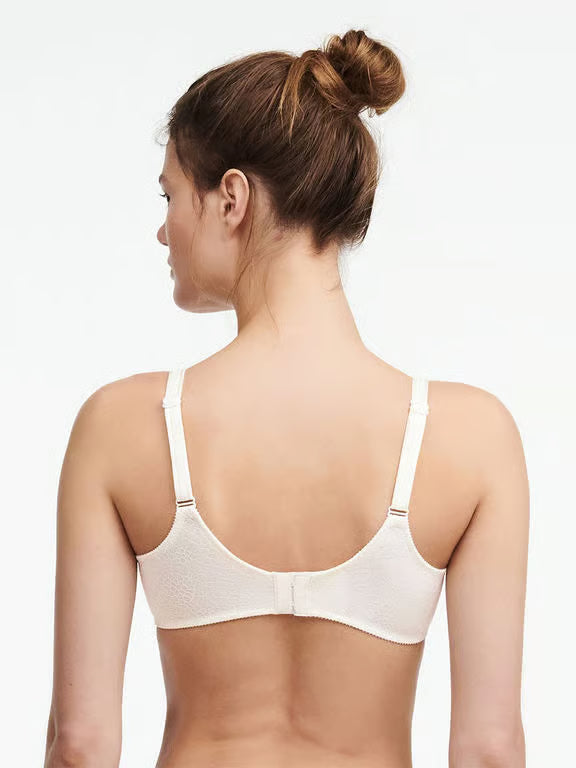 Woman wearing a white bra on a plain background