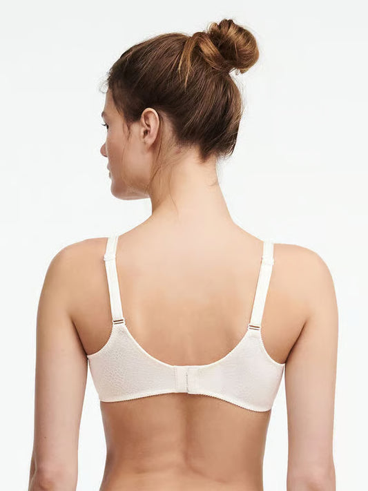 Woman wearing a white bra on a plain background