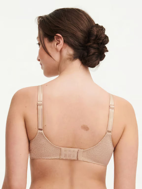 Woman wearing a beige bra on a white background