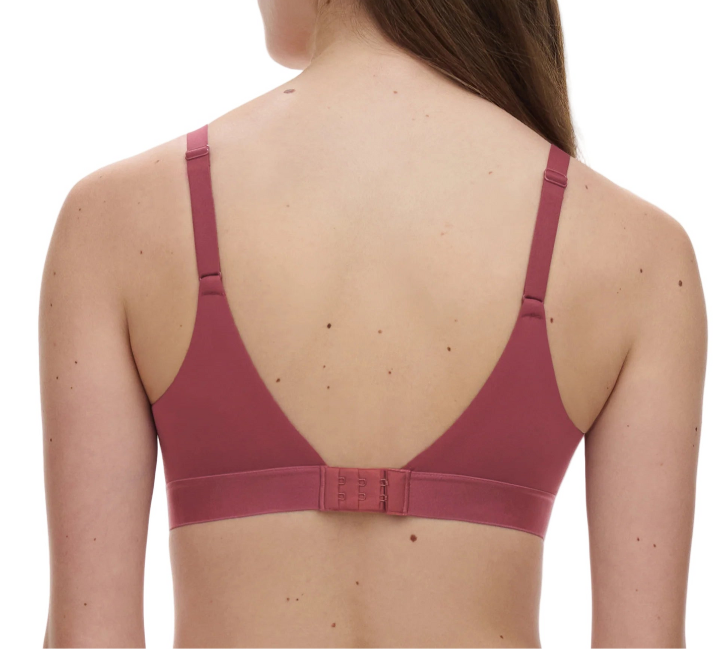 Woman wearing a maroon bralette on a white background