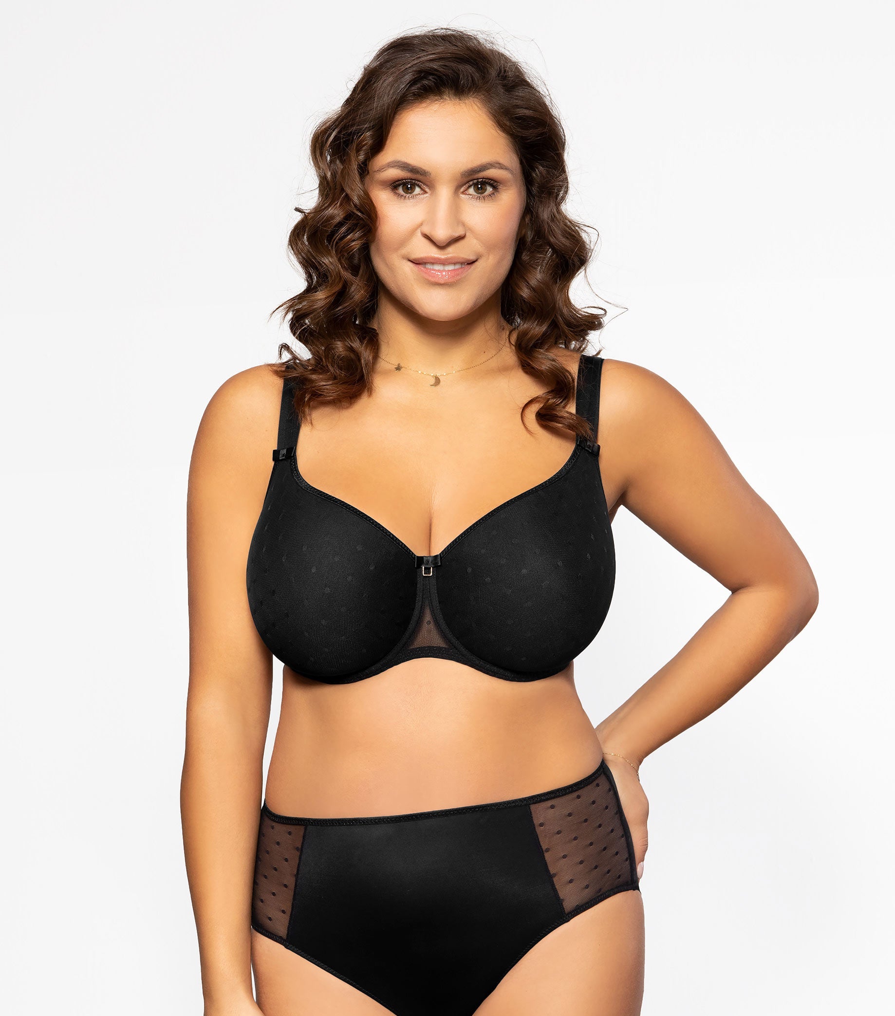Woman wearing a black bra and panties set on a white background