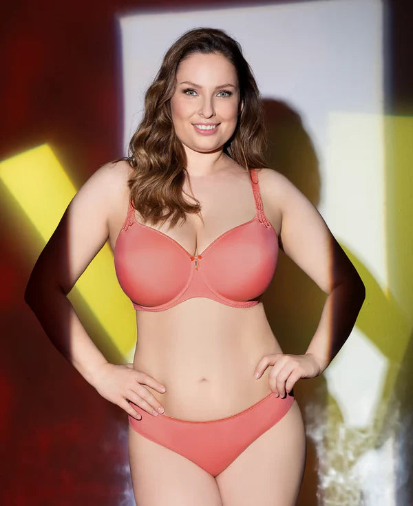 Woman wearing a coral bra against a colorful background