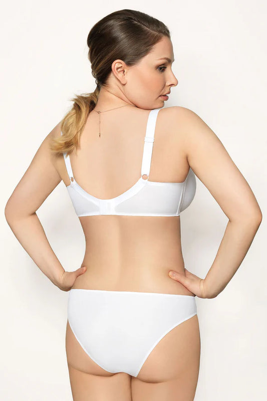 Woman wearing a white bra against a plain background