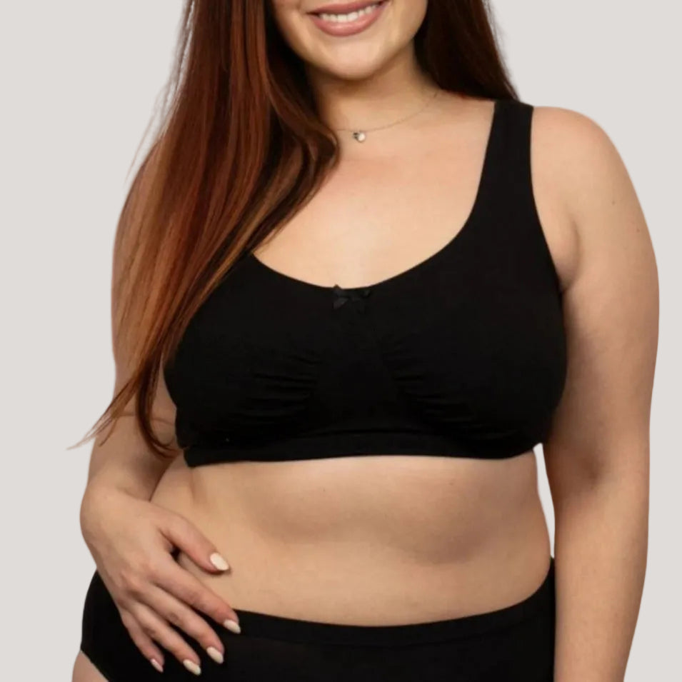 Woman wearing a black sports bra on a white background