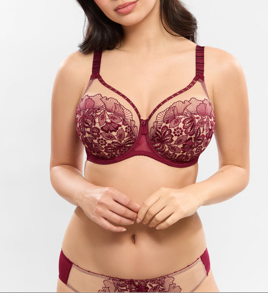 Woman wearing a burgundy lace bra and panties set on a white background