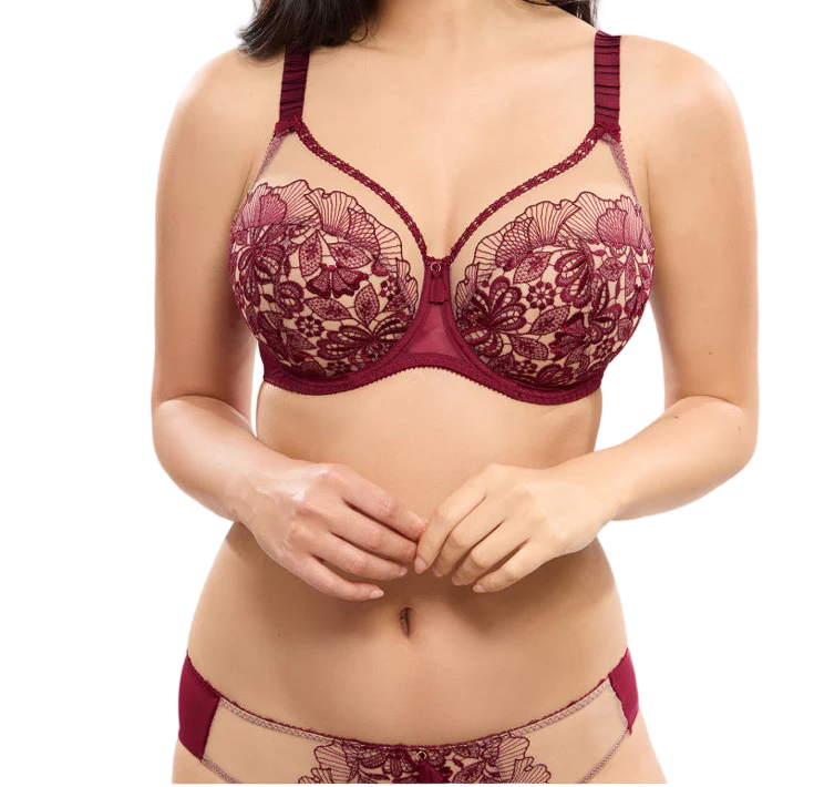 Woman wearing a maroon lace bra and panties set on a white background