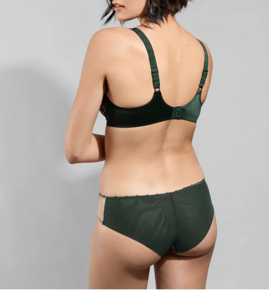 Woman wearing a green bra and panties set on a gray background