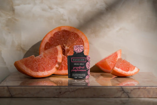 Bucalan grapefruit pomeloade bottle with sliced grapefruits on a marble surface
