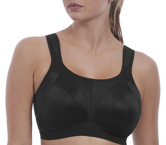 Woman wearing a black sports bra on a white background