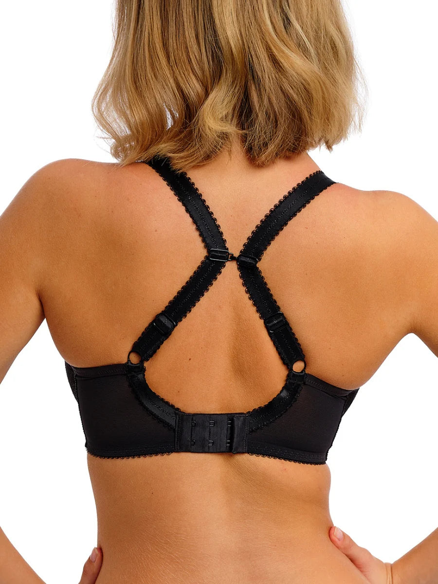 Black strappy bra worn by a person on a white background