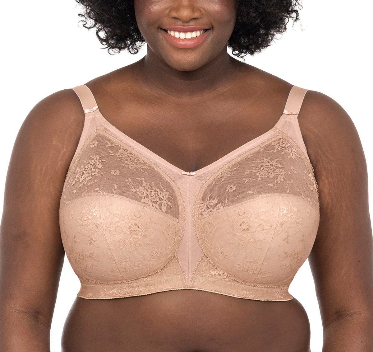 Woman wearing a beige bra with floral lace details on a white background