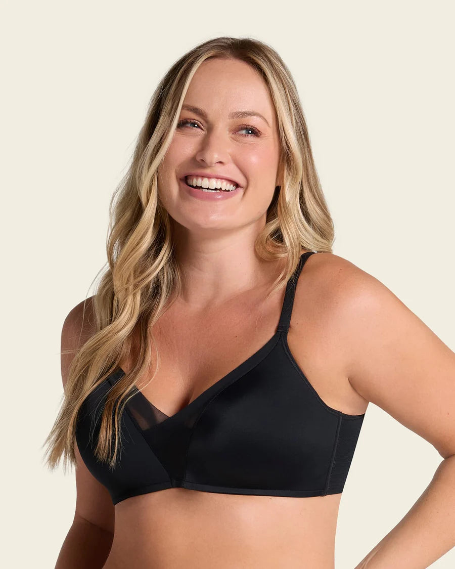 Woman wearing a black bralette against a beige background