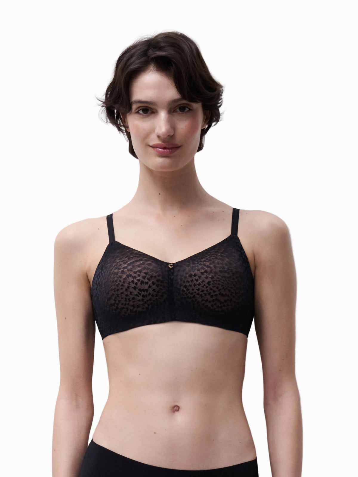 Woman wearing a black bra against a plain background