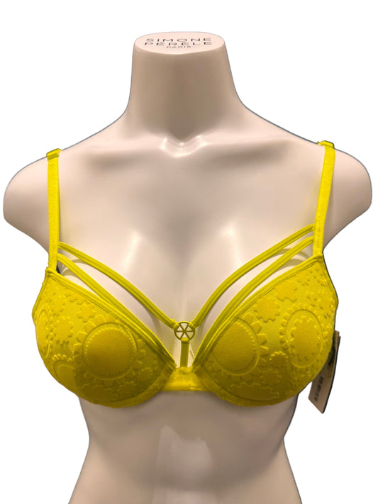 Yellow bikini top on a mannequin against a dark background