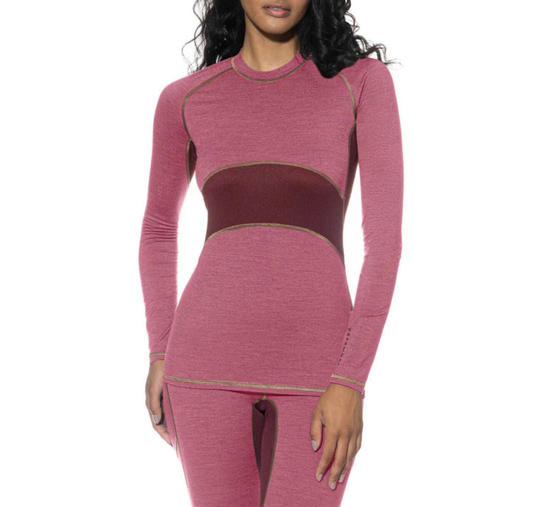 Woman wearing a pink long-sleeve top and leggings set on a white background