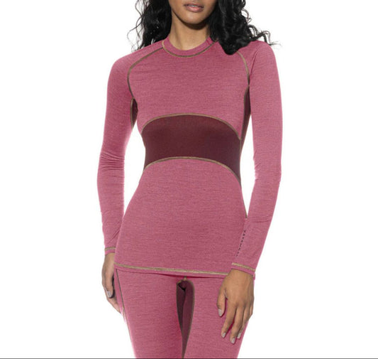 Woman wearing a pink long-sleeve top and leggings set on a white background