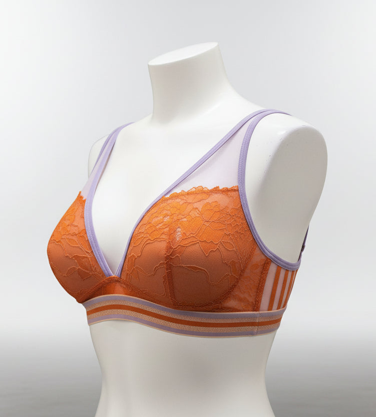 Orange bra with purple straps on a mannequin against a dark background