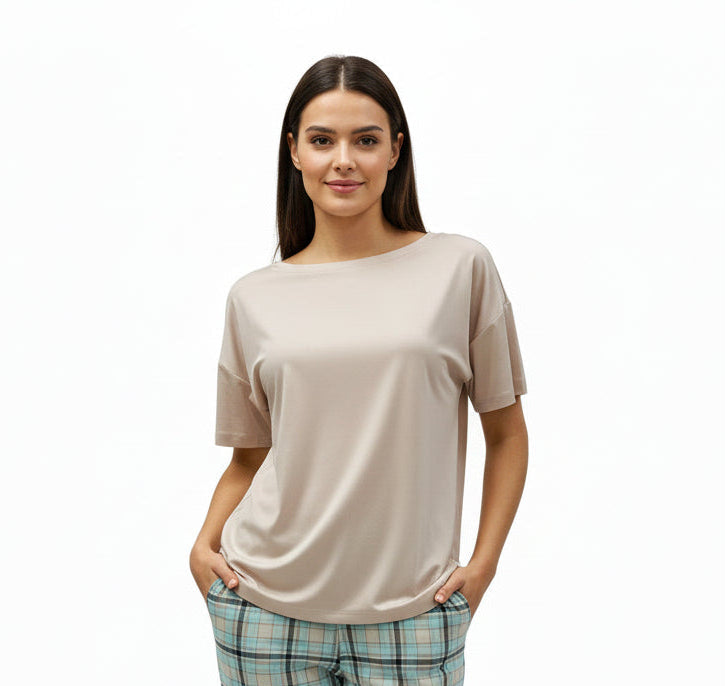 Mannequin wearing a beige top and plaid pj pants on a white background