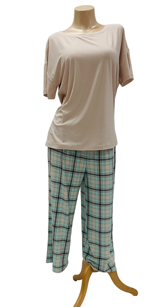 Mannequin wearing a beige top and plaid pj pants on a white background