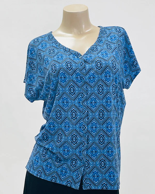 Blue patterned top on a mannequin against a gray background