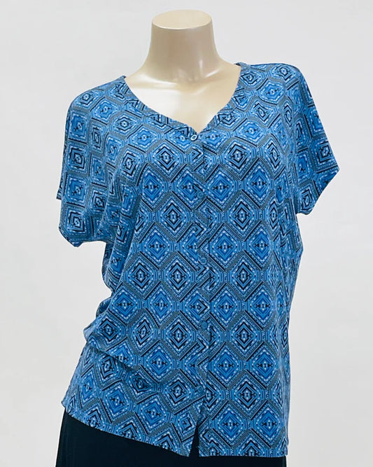 Blue patterned top on a mannequin against a gray background